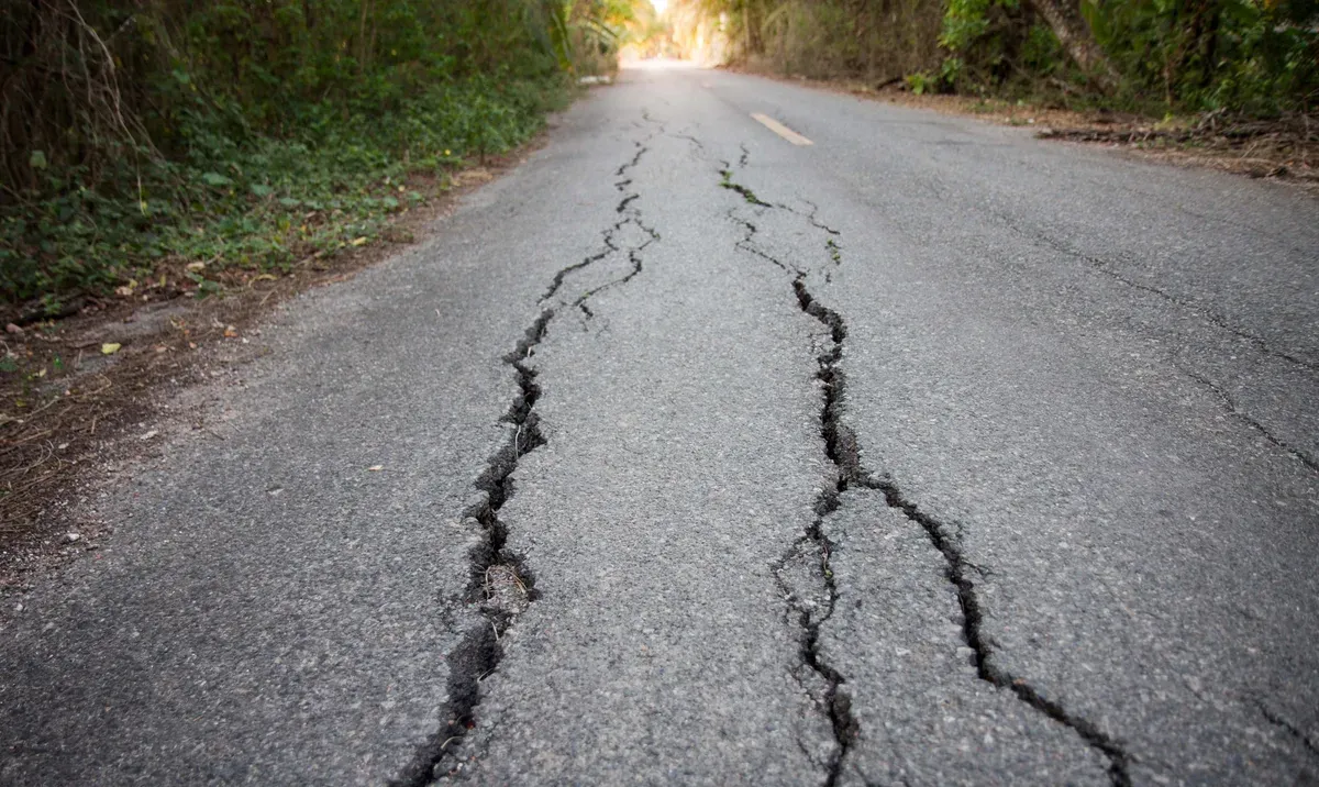 Earthquake cracks running down a bitumen road